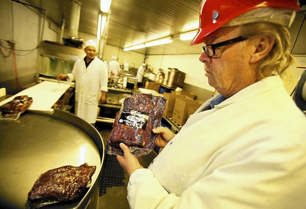 Jerry Haines, general manager of R.C. Provision in Burbank, holds pastrami that's ready for shipping. The company, which supplies Pink's, Langer's Delicatessen and other eateries, is struggling as beef prices have hit a record high in the U.S. (Al Seib, Los Angeles Times / March 28, 2014)